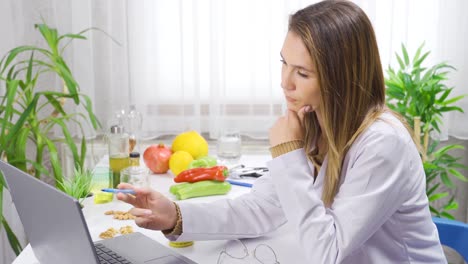 Nutritionist-working-on-computers-in-his-office.-Diet-and-healthy-living-plans.